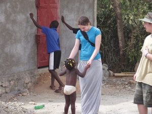 Five adults and three teenagers from Cook County traveled to Haiti in March to work at Fountain of Christ School. Above : Marin Hay makes a connection with one of the smallest students. Right: It was the job of the visiting Americans to greet the children as they arrived in the morning. Pastor Dale McIntire gets an enthusiastic welcome.