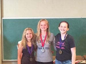 Above: Paige Everson stands next to second place finisher Anna Davenport and first place finisher Livi Papadopoulos in the U-13 girls logrolling division. Inset: Taylor Everson displays her certificate for her second place finish in the speed birling competition.