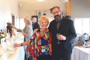 Left: Auctioneer Bill Hansen visits with Birch Grove Community School supporter Sue Hansen. Above: Chef Judi Barsness tried to stay out of the limelight, but attendees drew her out for a round of applause in appreciation for the delicious dinner.