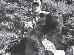 Photo courtesy of Minnesota Department of Natural Resources Greeley posing with one of the bears that was recovered from his freezer during the investigation leading to charges for poaching. Greeley did not have a valid license when shooting this bear.