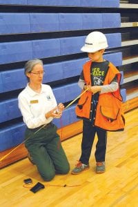 U.S. Forest Service staffer Myra Theimer shows a young student some measuring techniques.