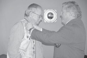 Lions Club District Governor Mark Osthus presents the Lions Club Presidential Award to Gene Erickson of Grand Marais on May 20.