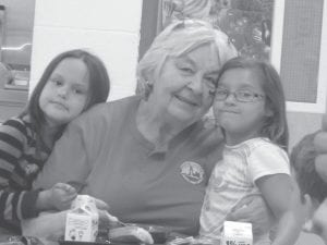 Summer has brought a flurry of activity to the Grand Portage Elder Nutrition Program. Above: The super Elders and readers who spent time together in the “Reading with Kids” program. The students and Elders had lunch together and the kids received their reading certificates and ice cream cones. Left: Carol Hackett enjoying lunch with reading students, Ashland Childs and Karianna Deschampe.