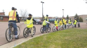 Top: Forty-two third grade students participated in a bike safety education program at Sawtooth Elementary and Great Expectations School in May. Above: Looking sharp in their bicycle helmets, these kids are ready to ride!