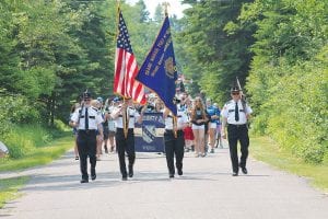 Left: The well-attended Tofte parade was led by the American Legion Post 413 Honor Guard, followed by the Cook County High School Band. Above: Enjoying a ride in the parade was the 2015 Tofte Citizen of the Year Bill Hansen, along with his wife Cindy and their dog, Roy. Bill received lots of cheers along the way for this welldeserved recognition for his work in the community.