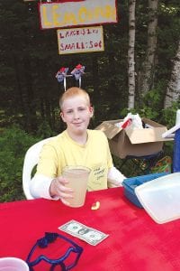 The Hovland community got into the Independence Day spirit at the Hovland Arts Festival. Left: Enterprising Doug had a lemonade stand with some red, white and blue flair. Above: In addition to beautiful art in and around the town hall, there was a great lunch at Trinity Lutheran Church, served by Sandy Petty, Sharon Bloomquist and Pastor Kris Garey.