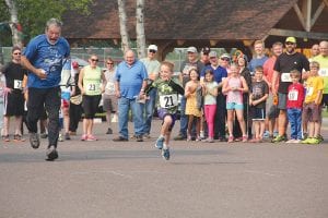 Top: Founder of the Tofte Trek 10K, Jan Horak oversees the kids’ races. This young man had no one to race with so Jan gave him some competition. Left: Steve Ramberg and his daughter Louise, of Grand Marais, finished the muddy 10K in just over an hour. Above: Mother and daughter duo Emma and Clair Nalezny finished the 10K walk together.