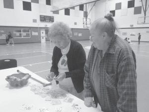 The Grand Portage Elders have been busy in July. Ellen Olson and Dottie Griffith check their poker hands to see if they won the pot during Wisdom Steps walking.