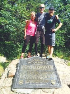 Some of the Tour de Fox hikers—Visit Cook County Executive Director Linda Kratt, Tour de Fox athlete Sam Fox, and Grand Marais Mayor Jay Arrowsmith DeCoux—celebrate at the summit of Eagle Mountain.