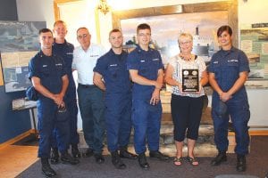 In attendance at the dedication of a plaque honoring Petty Officer Keith Brubaker who perished in the Grand Marais harbor in 1967, were (L-R) BM3 Justin Abbott, BM3 Erik Soderman, Coast Guard Reservist Ray Nagy, SN Chris Impagliazzo, BM3 Max Wienke, Sandra Brubaker Blacklodge, SN Megan Johnson.