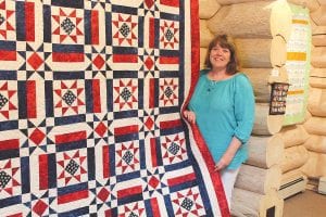 Nancy Backlund with the stunning Stars and Stripes quilt she created for the American Legion Auxiliary. The quilt is on display at the Northwoods Fiber Guild exhibit Through Our Hands IV at the Johnson Heritage Post in Grand Marais. The quilt is being raffled by the Legion Auxiliary.