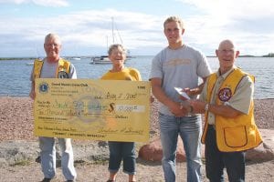 Jacob Schroeder of Grand Marais was the winner of the Fisherman’s Picnic raffle grand prize of $10,000. He happily accepted the “big check” from the Grand Marais Lions Club. (L-R) Dick Parker, Millie Spry, Jacob Schroeder, Bob Spry.