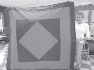 Betty Hoffman with the lovely and cozy quilt she made for the Elder’s Raffle at Rendezvous Days.