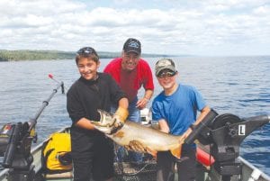 Dick Nelson of Lutsen had a fantastic day of fishing with these two young men. His 11-year-old grandson Carter Albright from Midland, Michigan brought his classmate, Jace Alaniz (left), to Minnesota for a visit. They spent three hours fishing on Lake Superior on August 11 and Jace, who had never fished before had the first chance at “Fish on!” This beautiful redfin lake trout was 38 inches long. It took both boys to lift the big trout for the photo. After the picture the fish was released, but the memories will last forever.