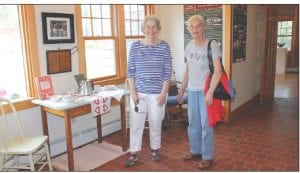 Left: Trina checks out the beautiful raffle quilt made by the Cross River Quilters. The stunning quilt has prairie point edging. Above: About 24 people took part in the historical walk while others enjoyed displays like Lost Resorts in the heritage center. Linda Lamb and Bobbie Bockovich (right) visit by an old resort table setting.