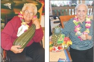 Left: Bernice LeGarde is the proud winner who guessed the weight of this zucchini—10.38 lb. It was worth its weight in dollars when Bernice won $10.38. The zucchini was grown by Diane Nowers, a volunteer at the Care Center. Right: Marie Jacobson won a pineapple plus $1 playing Hawaiian Bingo last week.