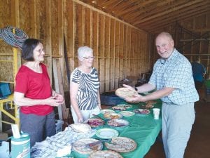 Upper left: GTHS President Dave Tuttle was pleased with the pie selection. Above: In addition to interesting displays and scenic nature walks, Chik-Wauk offered “voyageur games.” These young ladies enjoyed a cup and paddle race. Lower left: Steve and Shonna Netland enjoyed pie amidst the construction.