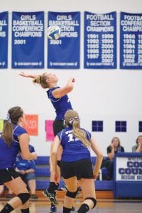 Far left: With Shauna Blake (No. 12) and Alex Slanga looking on, Lily Gruber-Schulz went up high and got ready to slam a spike past the Cromwell Cardinals' front line. Above: With Sarah Toftey ready to make an assist, Trace McQuatters took a hard serve and set it to her front line. Left: Emily Jacobsen deftly blocked this ball, which resulted in a point for the Vikings.