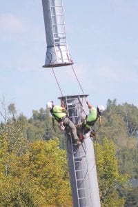 For the tallest gondola tower, the Sikorsky S-61 made two trips. After the first half of the tower was in place, these Doppelmayr workers climbed it and carefully guided the second pipe into place. The workers then scaled the 58-foot tower to attach the cross arm.