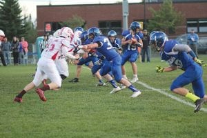 Top: Viking quarterback Leo Johnson gets ready to drop back and throw a pass to Owen Anderson on this play. Left: Ethan Sporn (No. 34) isn’t very big but the freshman led all Viking tacklers in their game against the Ely Timberwolves. Above: Joining the fray, Frankie Miller (No. 22) put the finishing touches on this group tackle to take down a determined Ely ball carrier.