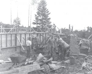 St. Olaf College students, church members and community members came together to build Trinity Lutheran Church in Hovland. This photo shows the work in progress in 1948. The large pine tree to the east of the foundation continued to grow beside the church building, but sadly toppled in October 2012. A church member attempted to count the tree rings—there were about 107. Duane and Virginia Johnson of Hovland carved what was left of the big pine into a beautiful rugged cross in the churchyard.