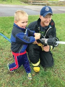 Birch Grove Community School students enjoyed a visit from Tofte Fire and Rescue during Fire Prevention Week. Of course spraying the hose was a huge hit. Left: Sophia Blanck models the glow-in-thedark firefighter hats the kids received. One little boy was heard saying, “You know, I think I could be a firefighter when I grow up!”