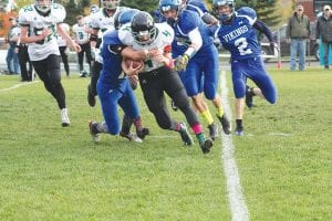 Top: A hallmark of Viking football is gang tackling. Here Rory Bakke (left), Owen Anderson and Colton Furlong (right) work together to take down the Littlefork-Big Falls ball carrier. Left: Owen Anderson made a leaping catch on this ball despite the defender's best attempts to break up the pass. Above: Jack Wieben stiff-arms the would-be tackler as he scampers for a big gain.