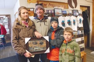 Above: The winners of the Bear Track Outfitters’ Moose Madness medallion search were (L-R) Alexis White, Jon Cowden, Kaylub White and Kayden White. Left: The Grand Marais Library offered moose crafts and artifacts, like the big antler being checked out by Nora Young and her dad, Neal.