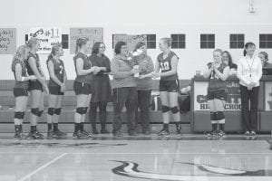 As senior Maddy Roy (far right) made an announcement to the crowd on October 22, Lily Gruber-Schulz presented Head Coach Pam Taylor with flowers from the team before the last game of the season against Floodwood. (L-R) Hannah Toftey, Meredith Sutton, Sarah Toftey, Emily Jacobsen, Assistant Coach Kasia Schmidt, Taylor, and Assistant Coach Kelly Roberts.