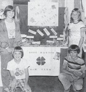 The 67th annual Cook County Fair held in August 1981 featured 73 exhibitors and 418 exhibits in the open class. In all, there were 12 purple ribbon winners, 225 firsts, 119 seconds, 53 third and 11 fourth–place prizes awarded. Shown here is the Rose Harbor 4-H Club, which won both a purple and blue ribbon for their booth. The club was represented by Tracie Smith and Ryan Bockovich (left) and Lisa Smith and Randy Bockovich (right). Other members of the club, Colleen Koss, Jerry Koss, Kelli Carlson and Jeremy Bowen were not present for the photo.