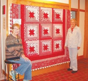 The Cross River Quilters “Cozy in Red” quilt project for 2015 will be raffled at the Cross River Heritage Center on November 21 at 2:00 p.m. Polly Erickson (right) worked through the winter of 2015 creating the lion’s share of the quilt. Finishing touches were added by the rest of the Cross River Quilters including Dory Spence (left).