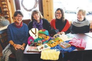 Many Northwoods Fiber Guild members gather at Java Moose on Tuesdays to visit and share their latest projects. Checking out some of the items that will be on display at the December 5 Fiber Guild Holiday Show and Sale are (L-R) Nancy Haarmeyer, Nancy Backlund, Nina Simonowicz and Ann Hegg.