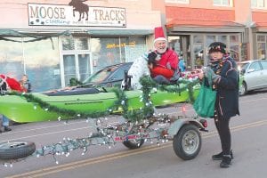 And the winner is…Left: Joy & Co.’s Paisley Howard-Larsen looked adorable in Christmas long johns. Above: Jack Stone and Stone Harbor Wilderness Supply won the Best Holiday Spirit award in the 2015 Oh Ole Night parade. Suzanne Sherman, with the Ruby’s Pantry marchers, visits along the parade route.