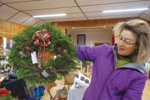 Linda Newman considers a lovely wreath at the Hovland Town Hall. Wreaths and more for holiday decorating were available.