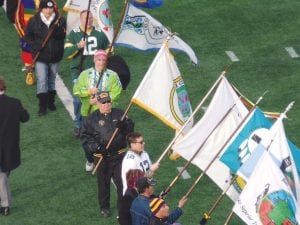 In the historic Native American Heritage Month event at TCF Stadium, Butch Deschampe (center, in black jacket and Vietnam veteran cap) was the flag bearer for the Grand Portage Band of Lake Superior Chippewa.