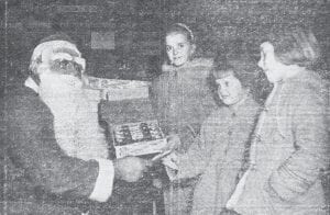 A Christmas party given by the Grand Marais Lions, Chamber of Commerce and the school in December 1961 was well attended, although it was a mystery how St. Nick came down the chimney at the school’s social room, since there is no chimney. Shown with Santa, from left, are Patty Finn, Margaret Ruth Sjoberg and Kathleen Sjoberg.
