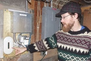 Above: Grand Marais Mayor Jay Arrowsmith DeCoux points to the monitor that displays how much power the solar panels generate.