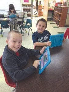 Above: These boys had a great time during the “Hour of Code” event in December. Right: Community volunteers also learned about code with the kids.