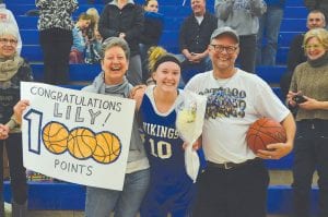 It was a happy moment when the referees stopped the game and Lily Gruber-Schulz was presented with flowers and a game ball commemorating her going over 1,000 points for her high school career. Lily is pictured here flanked by her two biggest fans, her mom, Jennifer, and her dad, John.