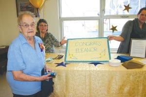 Volunteer extraordinaire Eleanor Waha received an award and a party in her honor for her more than 50 years of volunteer service at the Cook County North Shore Care Center. Eleanor has baked more than 600 birthday cakes for residents in that time, and she makes sure to keep residents up to date with all of the latest news and happenings of the day on her almost daily visits. Of the gifts she received on Feb. 25, her favorite, she said, was a wreath made of cards with messages written to her from the residents. Holding the cake behind Eleanor are Nora Bockovich (left) and Hilja Iverson.