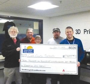 Underneath a new LED fixture are (L-R) Tim Kennedy and Karl Hansen, of the Grand Marais Public Utilities Commission (PUC), Jan Smith, PUC Administrative Specialist, Tom Nelson, maintenance supervisor for Cook County Schools, and Adam Nelson, Cook County Middle School and High School principal.