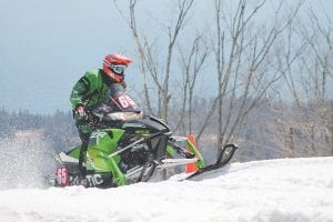 Far left: Casey Pries almost touched the sky in the Pro Factory 600 race, which he won. Above: Taylor Cole gets the green flag, signaling his race is almost finished. Left: Spectators had a great time—and some were as colorful as the snowmobiles!