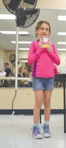 A happy Alexis Plummer proudly displays the first place trophy she was awarded after she defeated a field of boys and girls competing in the U-7 co-ed division at the Harold Fischer log rolling competition.