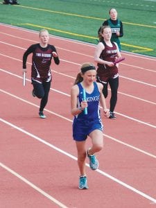 Far Left: With baton in hand, Hazel Oberholtzer, in front of the pack, powers home. Above: Linnea Henrikson shows off her hurdling form. Left: Will Surbaugh ran a fast (5:19) 1,600 meters for his age.