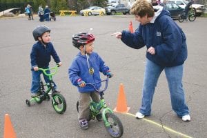 North Shore Health Administrator Kimber Wraalstad gives instructions to these two handsome young fellows about how to safely ride their bicycles through a tricky course marked in chalk in the parking lot of the Cook County Community Center. Wraalstad was just one of many volunteers who helped with the annual Moving Matters Bike Safety Rodeo held Thursday, May 12.