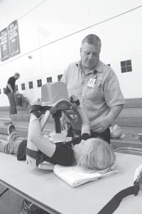 Steve DuChien not only serves on the statewide Emergency Medical Services Regulatory Board, he is active in the emergency services in the community. DuChien is pictured here at the Career Day event at Cook County Schools, sharing information on medical devices with an elementary school student.