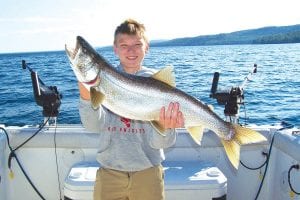 Captain Darren Peck reports that the “Matz brothers” are at it again. The brothers from Deephaven, Minnesota were featured in the Cook County News-Herald in 2011 with their very nice catch of salmon and lake trout. Last week they were on the water once again. Beckett (left), 12, caught a 27-inch, 8 pound steelhead which was released. Not to be outdone, Jasper (above)landed an 11-pound, 31-inch lake trout.