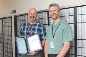 On Thursday, June 30, his last day at work at the Grand Marais Post Office, Postmaster Frank Lehto (left) received well-wishes from Acting Manager of Operations for Area 4 Eric Brademan.