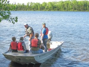 Left: “Take a Kid Fishing Day” was celebrated in Cook County on June 11. Kids got to get out in a boat on Kimball and Mink lakes. Above: These young men were delighted with the catch of the day.