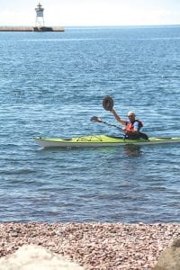 Top: A kayaker enjoying the North Shore Water Festival uses his hat to wave to the crowd. Above: This young lady waits for a chance to relax in a hammock set up on the shore. Right: Waving to his fans, Skipper the Seagull was a crowd favorite.